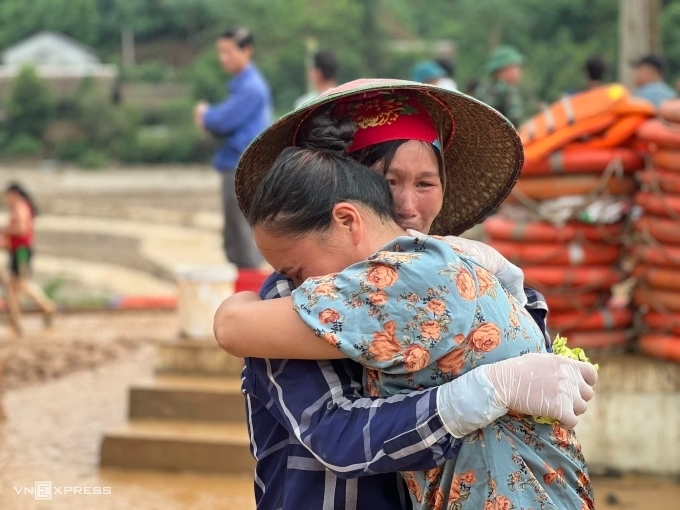 Chị Hoàng Thị Cảnh (áo xanh) ôm chầm hàng xóm khi ngóng tin chồng tại thôn Làng Nủ.