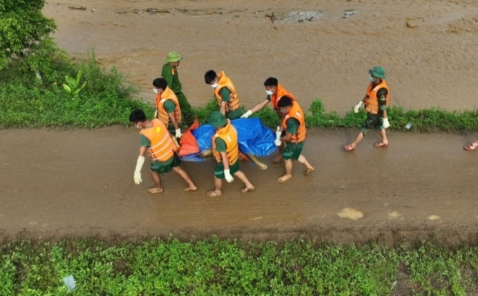 Các chiến sĩ đưa thi thể nạn nhân ra khỏi hiện trường, sáng 12/9. Ảnh: Ngọc Thành